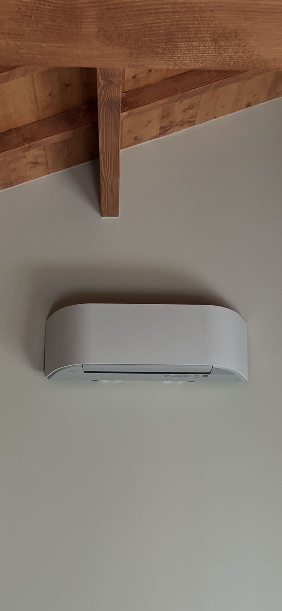 Climatisation murale installée sous charpente bois
