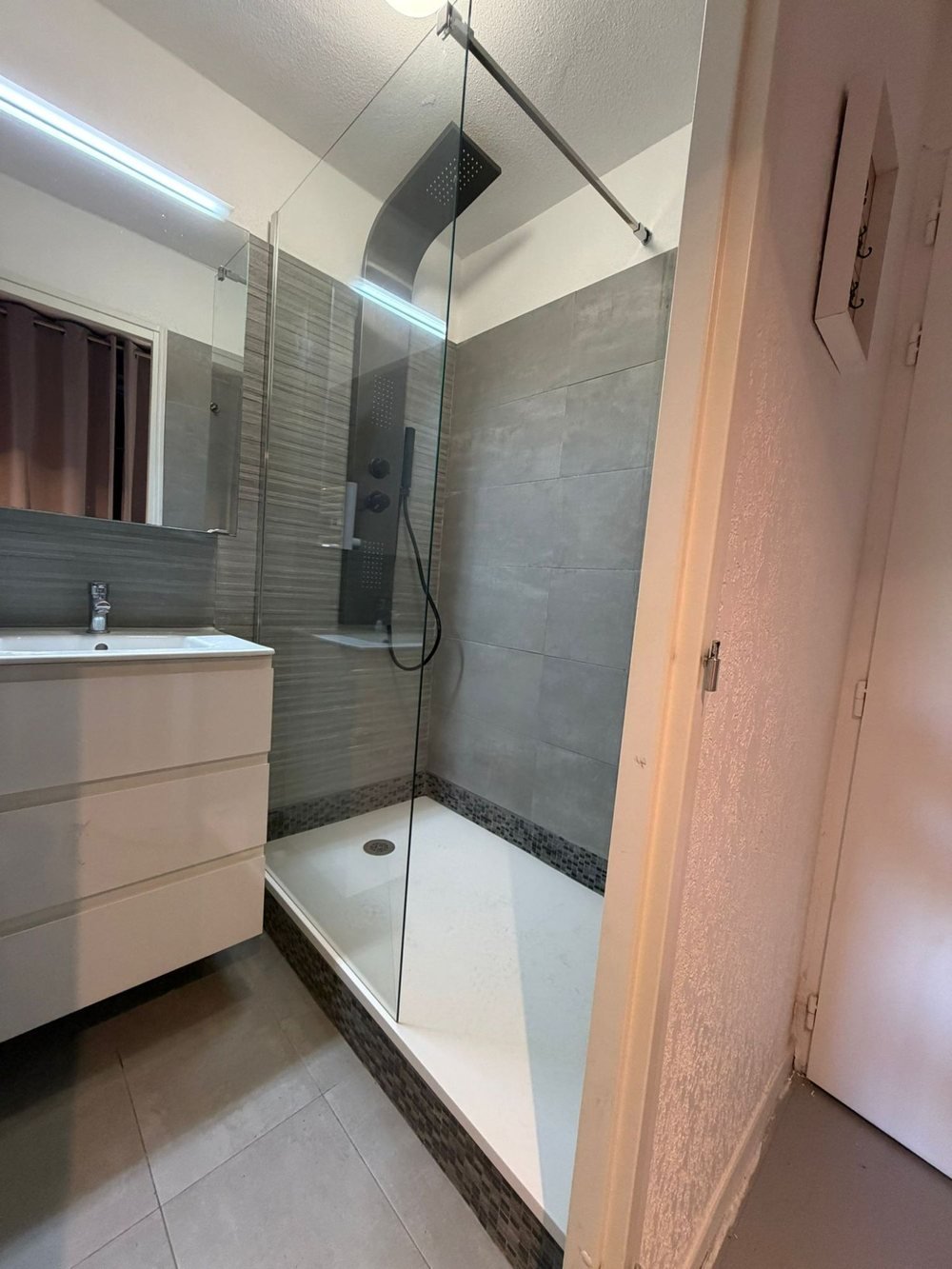 Salle d’eau rénovée avec douche à l’italienne et paroi vitrée